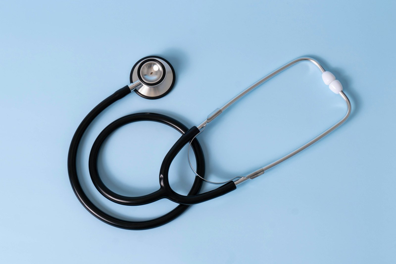 A medical stethoscope on a light blue background
