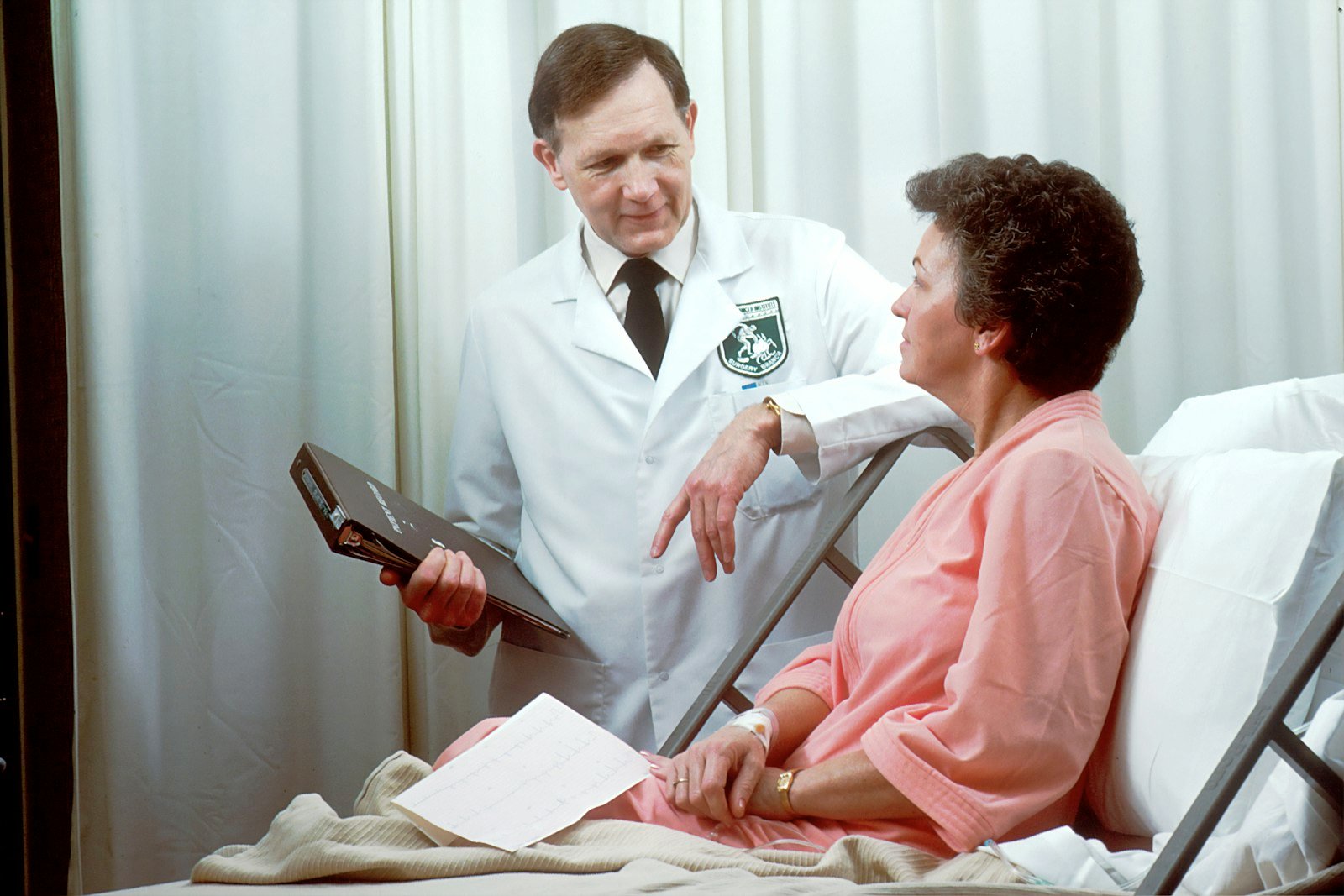 A doctor talking to a patient in a hospital bed